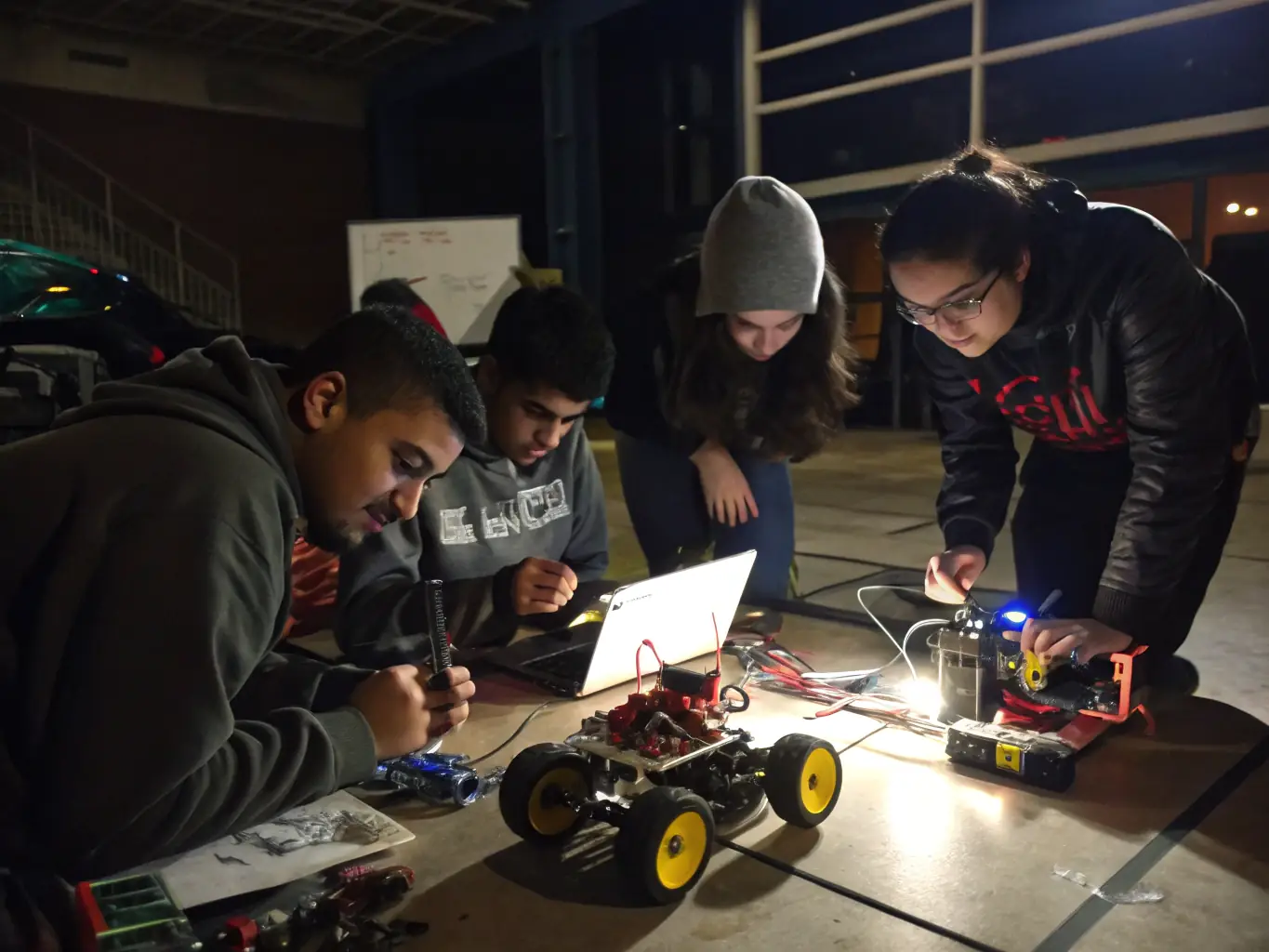 A diverse group of students participating in a robotics workshop, assembling and programming robots to perform various tasks.